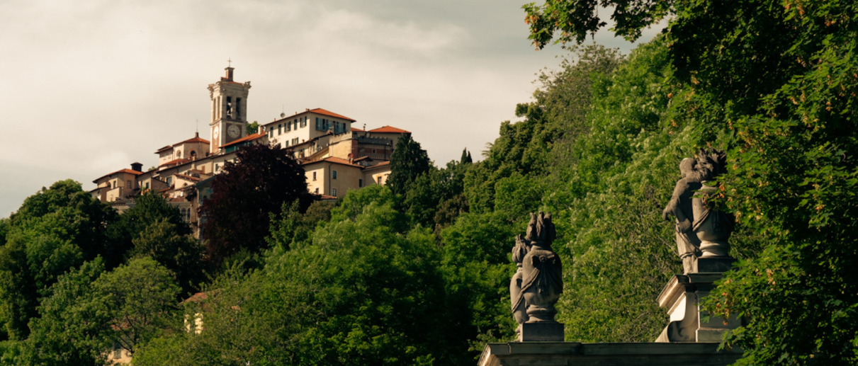 Vista suggestiva della decima cappella del Sacro Monte di Varese, con l'arco in primo piano, riflettente la bellezza artistica e spirituale di questo sito UNESCO