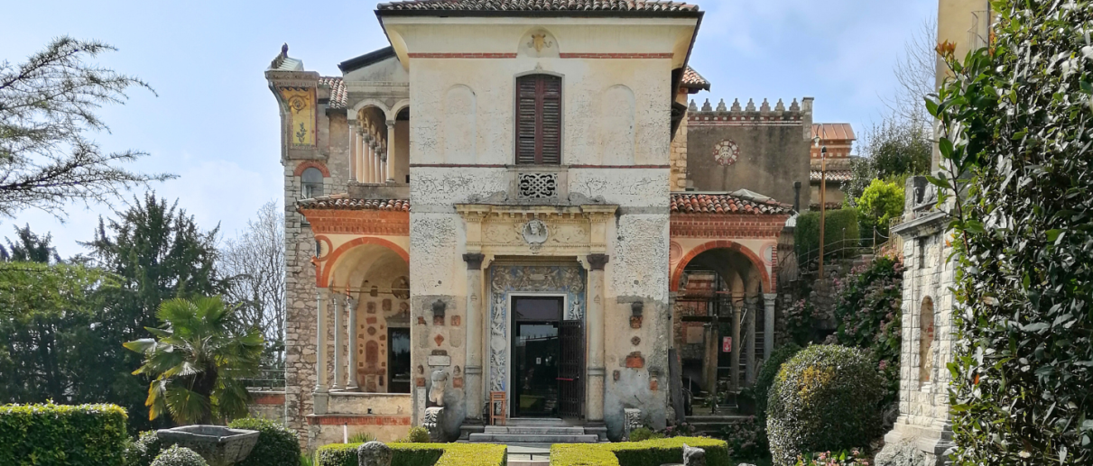 Hedges of the garden and entrance gate of the Lodovico Pogliaghi House Museum at Sacro Monte di Varese on a sunny day.